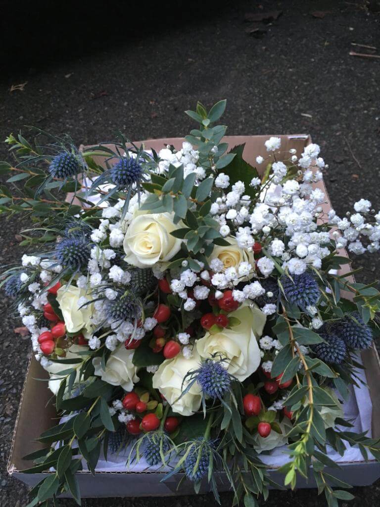 Cream brides bouquet with hints of red and blue